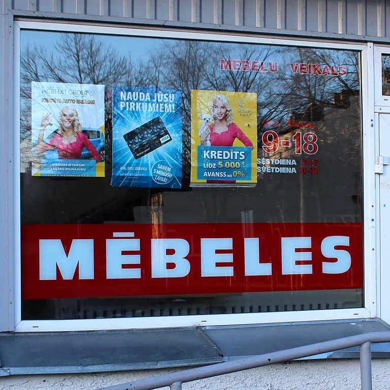 Skatlogu uzlīmes mēbeļu veikalam ar reklāmas uzrakstu MĒBELES, darba laiku un informatīviem plakātiem.